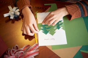 woman’s hands making a holiday greeting card