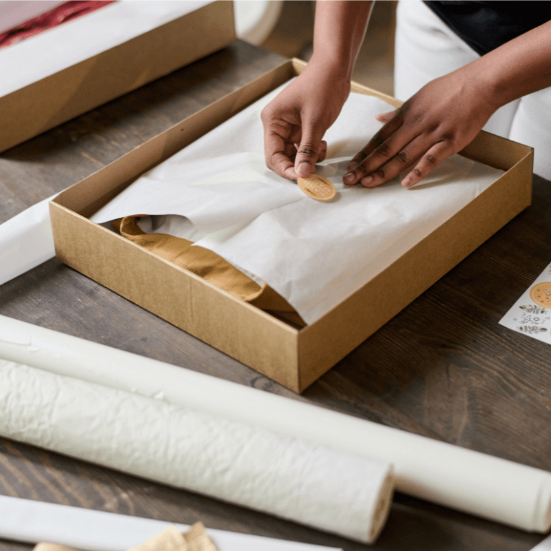 woman putting on custom stickers onto packaging