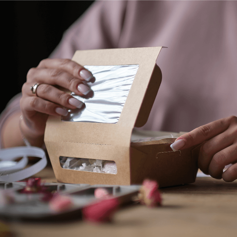 small business owner folding along dieline for packaging